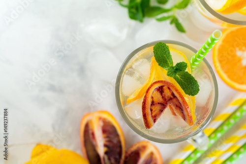 Tableau sur toile Cold and refreshing infused detox water with  orange, lemon and ice  in glass on a light background