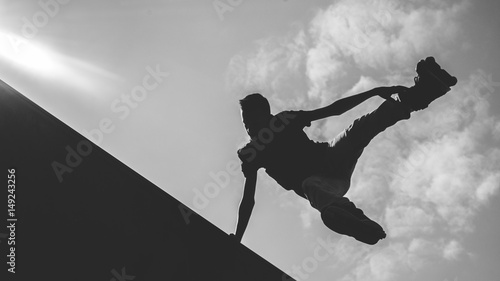 inline skater silhouette jumping at clouds sky