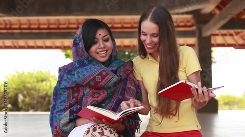 European woman volunteering in Nepal, teaching a poor asian woman to speak English language