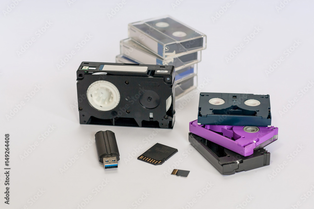 MiniDV and VHS video tape isolated on white. SD and MicroSD cards.  Cassettes. USB 3.0 pendrive. Stock Photo