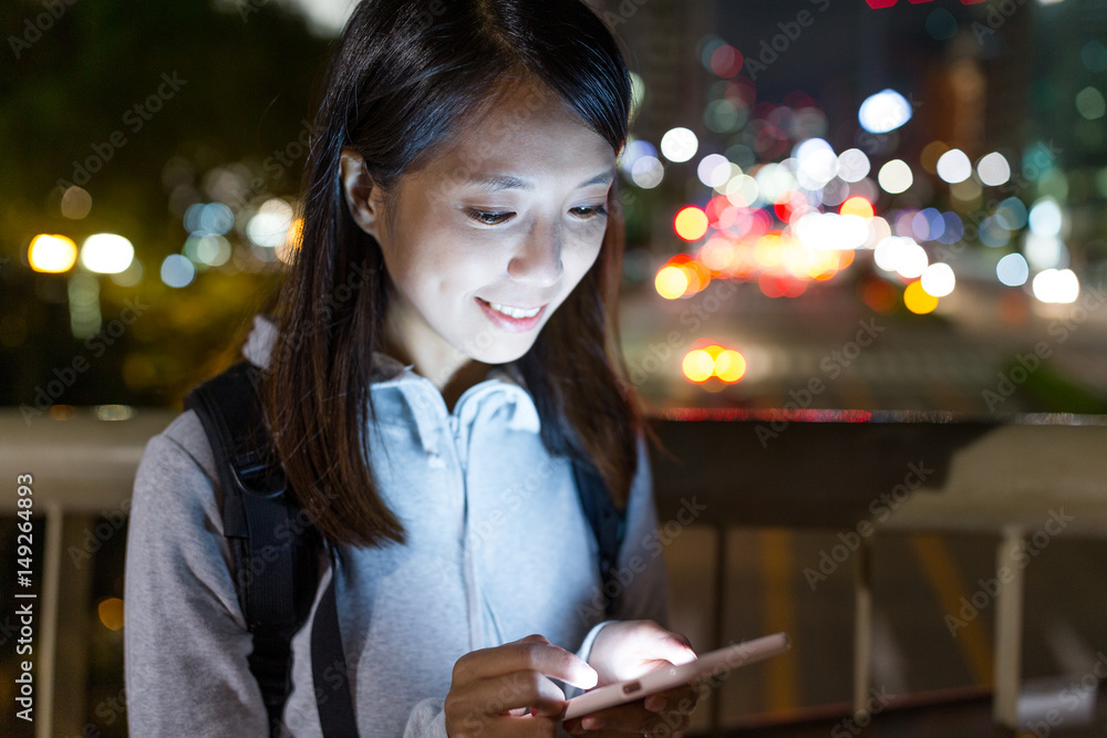 Woman using cellphone in Nagoya city at night Woman using cellphone in Nagoya city at night
