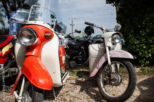 Fototapeta Naklejka Na Ścianę i Meble -  Retro old scooter motocycles on meet of classic cars
