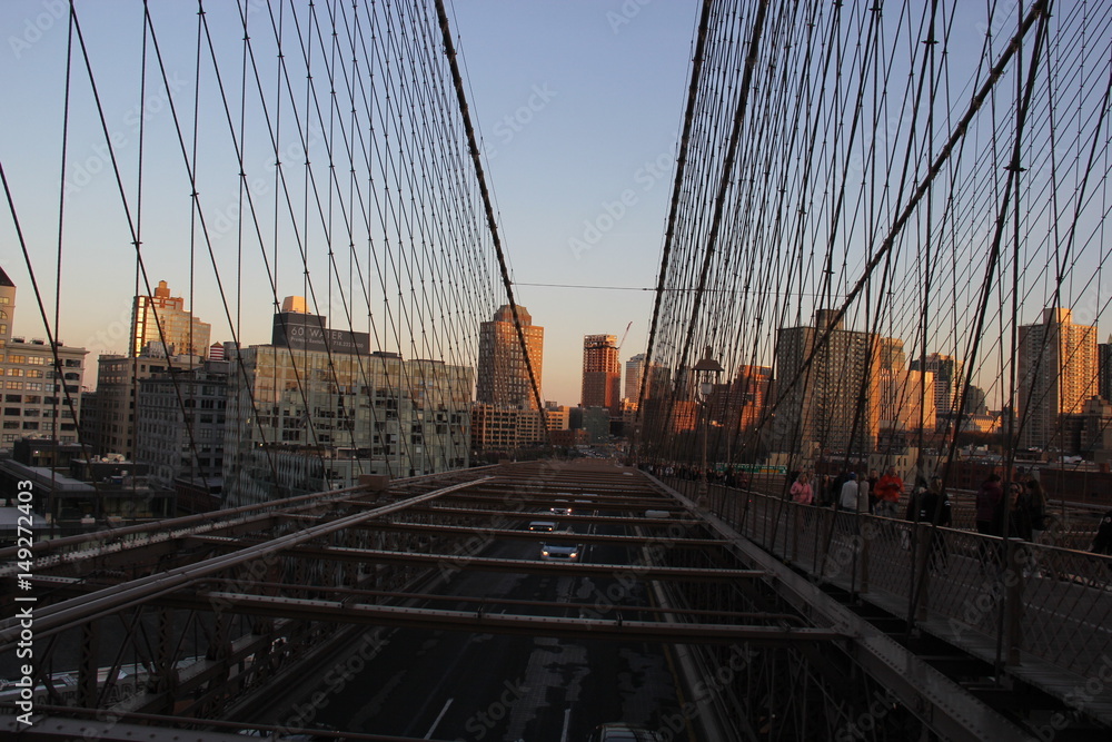 Naklejka premium Manhattan skyline at sunset from Brooklyn Bridge