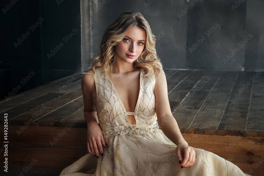 Fototapeta premium Fashion model in long dress on the metal background