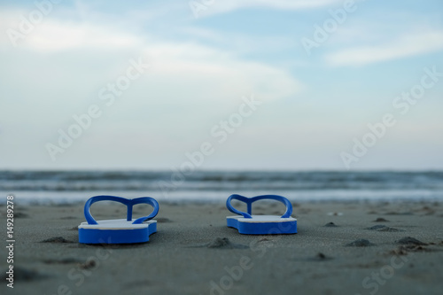 Travel concept,Shoes on the beach with sea background.