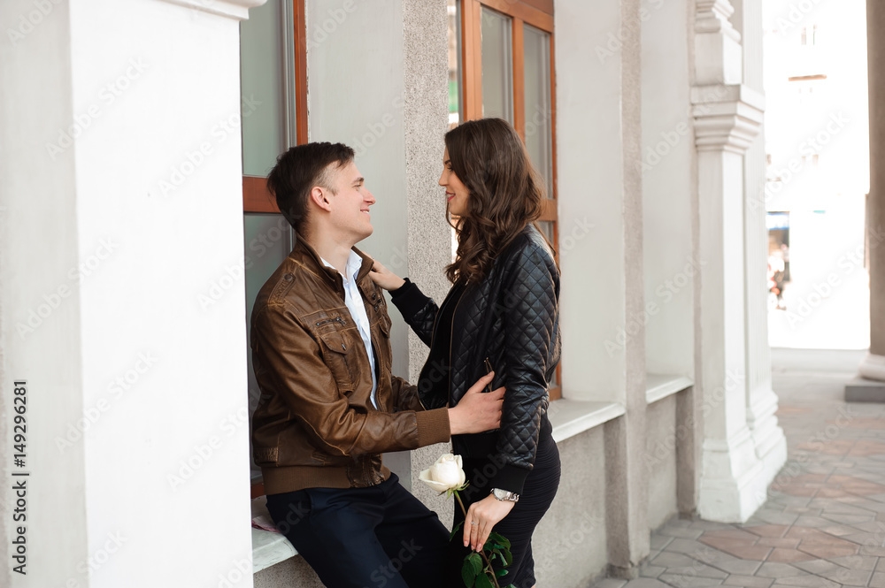 Fototapeta premium Young beautiful couple in love posing outdoor in city. Young woman smiling with her handsome man