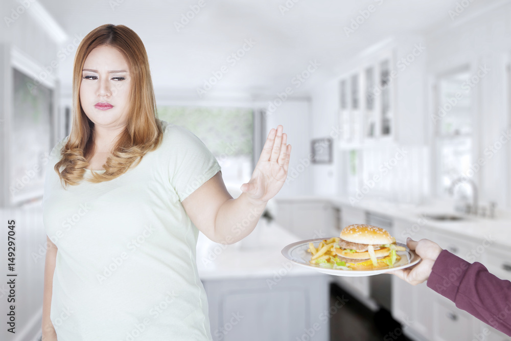 Fat woman refusing to eat hamburger Fat woman refusing to eat hamburger