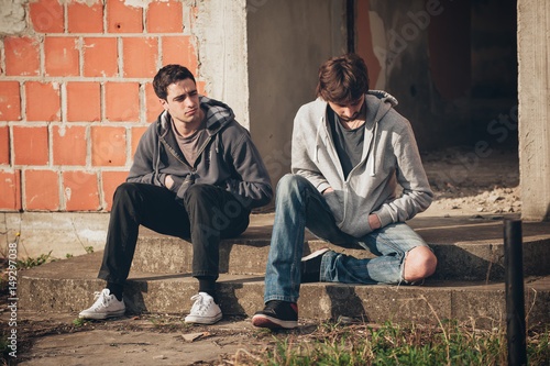 Two depressed and sad young buddies friends thinking about problems
