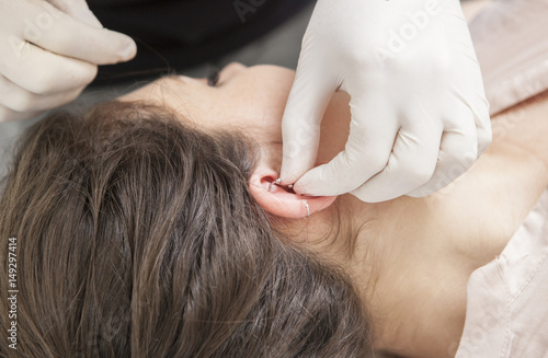 Quadro em tela Professional making rook piercing in the ear