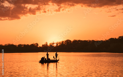 Obraz na plátně People are boating and fishing under sunset