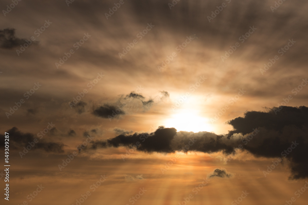 Setting sun behind beautiful clouds with God Rays