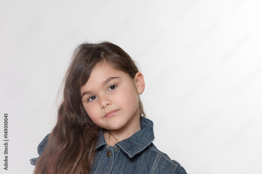 Portrait of brunette long haired little girl on the gray background. Portrait of brunette long haired little girl on the gray background.