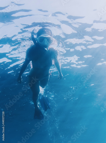 Female freediver snorkeling underwater.