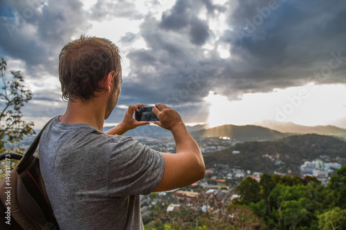 мужчина снимает пейзаж на смартфон