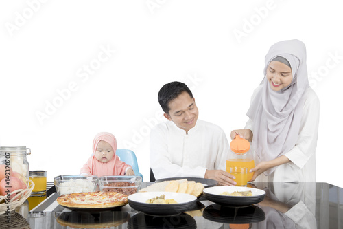 Wife pouring orange juice in a glass