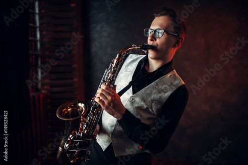 Male saxophonist playing jazz melody on saxophone