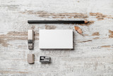 Photo of blank stationery set. Bank business cards, pencil, usb flash drive and sharpener on vintage wooden table background. Template for branding identity for designers. Top view.