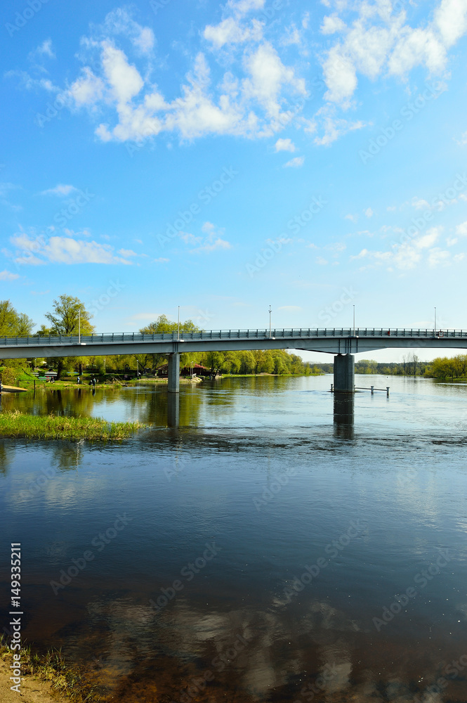 Most nad rzeką, brzegiem  i drzewa w Pułtusku.