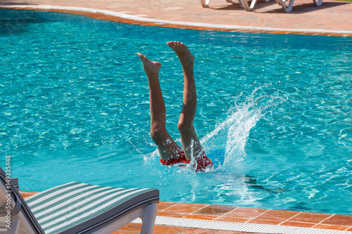 Teen boy dives and swims in the pool