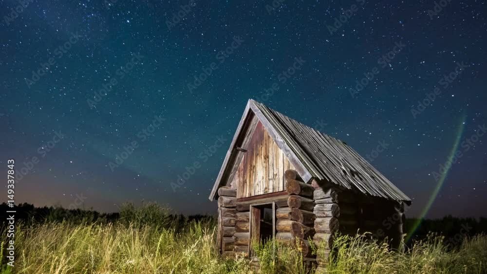Time lapse of starry sky at the edge of the forest with cabin log house in the foreground in summer. Time lapse of starry sky at the edge of the forest with cabin log house in the foreground in summer.