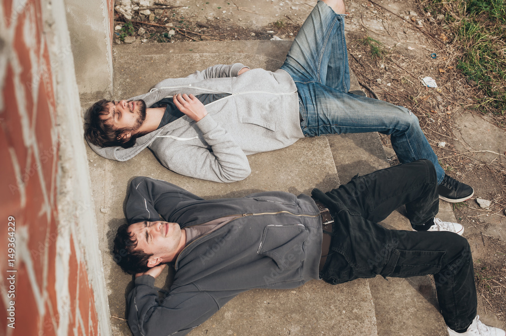 Two friends lying on the ground and smoke grass Two friends lying on the ground and smoke grass
