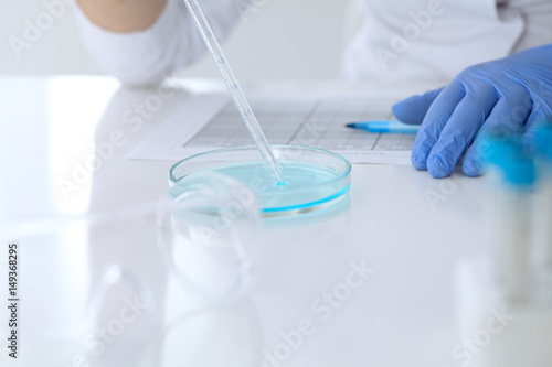 Close up of scientific research hands with clear solution in laboratory