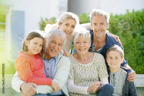 Portrait of intergenerational family sitting on bench © goodluz
