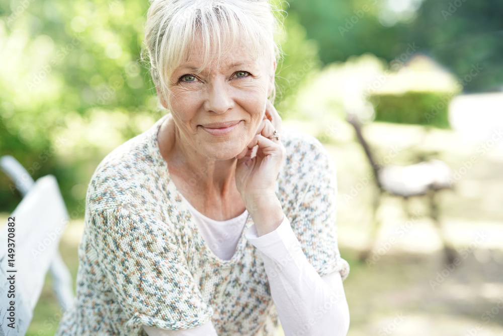 Portrait of smiling senior woman relaxing in garden Portrait of smiling senior woman relaxing in garden