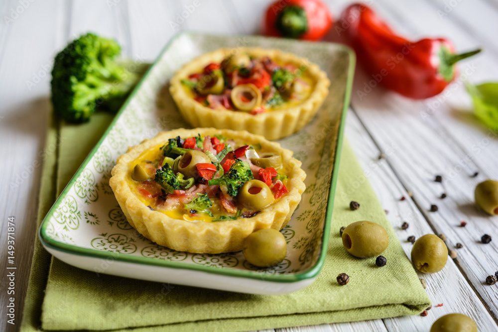 Salty tartlets with bacon, bell pepper, broccoli, cheese, onion, egg and olives Salty tartlets with bacon, bell pepper, broccoli, cheese, onion, egg and olives