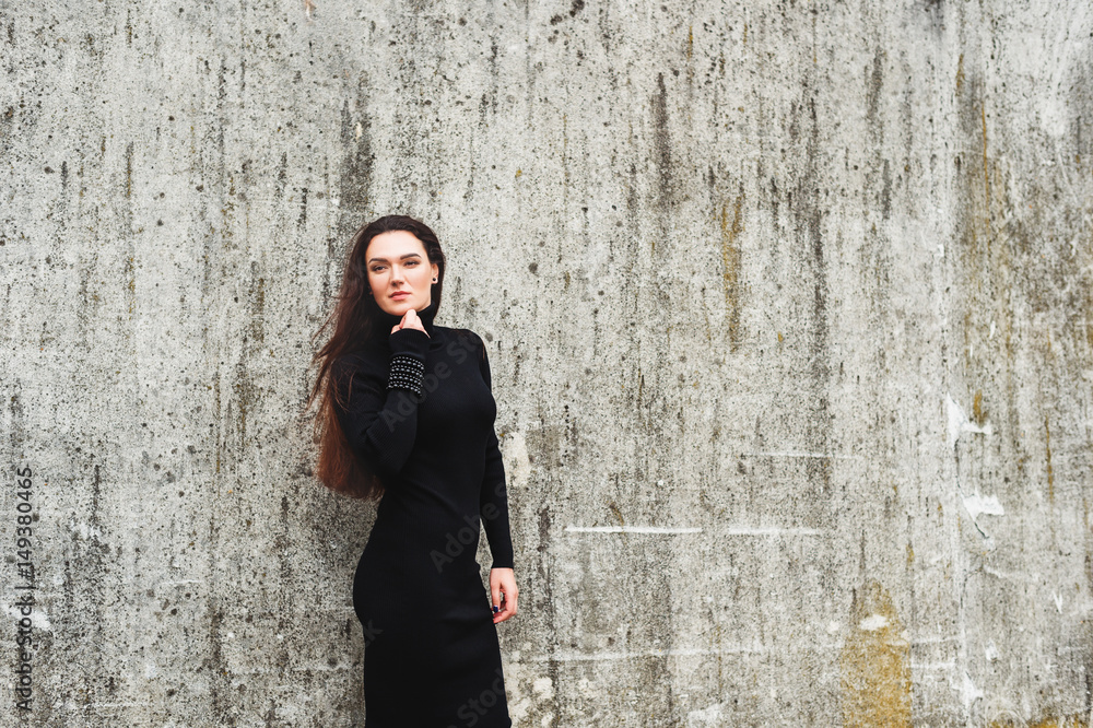 Outdoor portrait of young 35 year old woman with long dark hair, wearing black turtle neck dress Outdoor portrait of young 35 year old woman with long dark hair, wearing black turtle neck dress