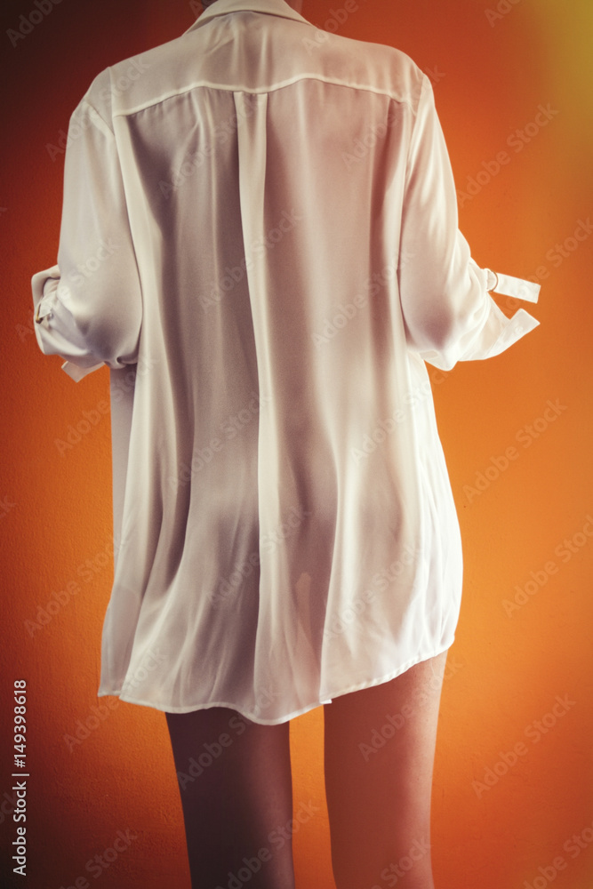 Chica con camisa blanca y fondo naranja. Stock Photo Adobe Stock
