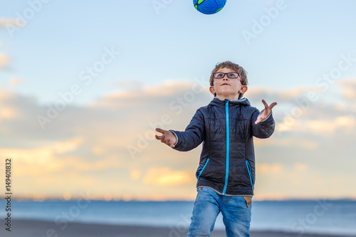 Boy with his ball at seaside photo