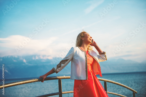 Outdoor portrait of laughing beautiful blond woman talking on the phone © annanahabed