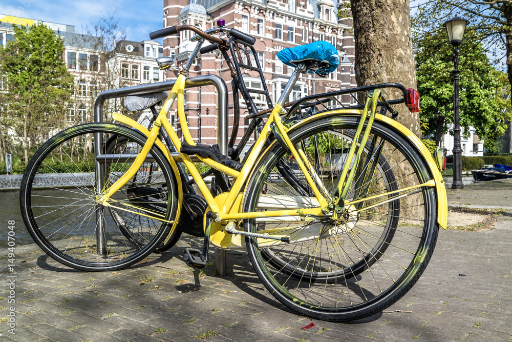 Yellow bike parked in the streets of amterdam Yellow bike parked in the streets of amterdam
