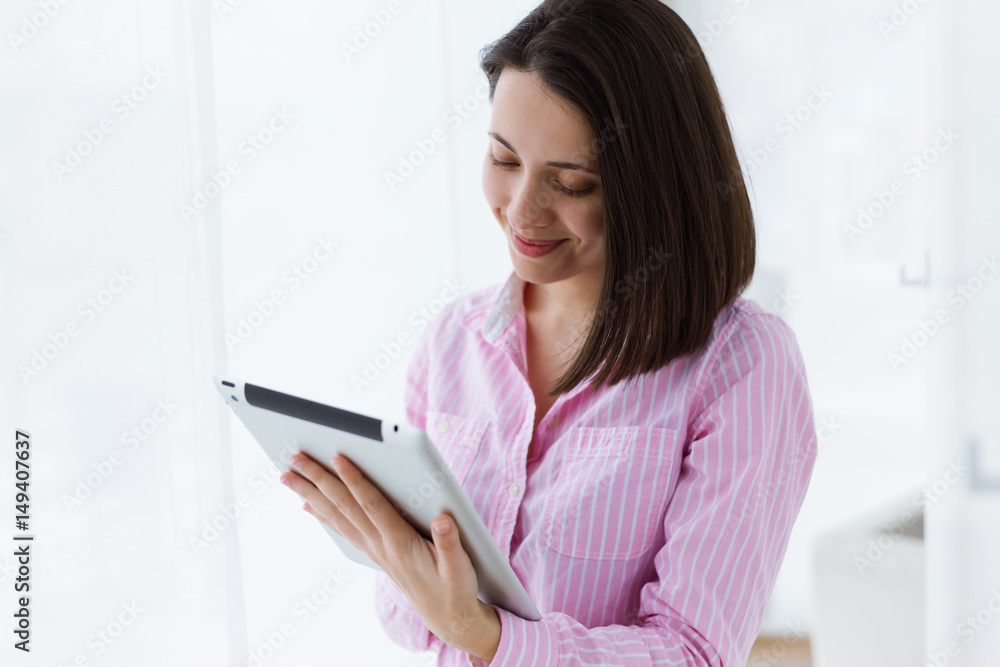 Beautiful young woman using her digital tablet in the office. Beautiful young woman using her digital tablet in the office.