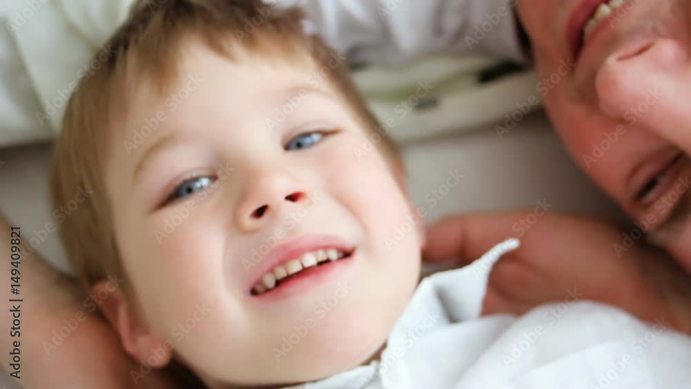 father with son at home lying on the floor and fooling around