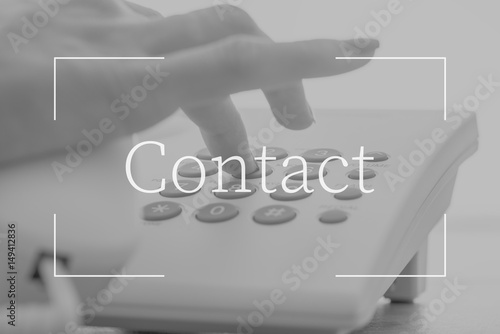 Contact text over female hand dialing a telephone number