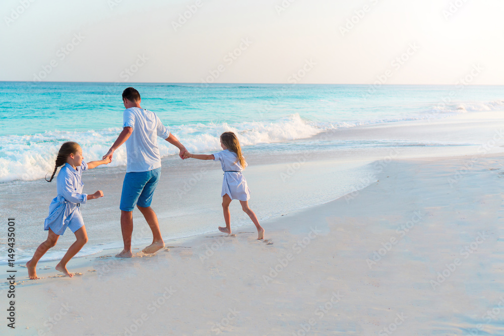 Family walking on white tropical beach on caribbean island