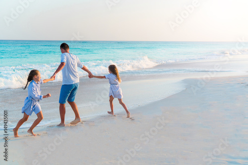 Family walking on white tropical beach on caribbean island