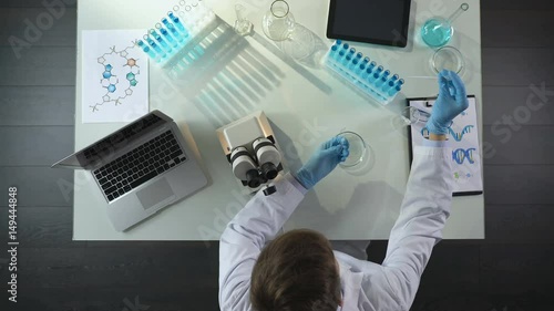 Biology student working with microscope, preparing sample to study, top view
