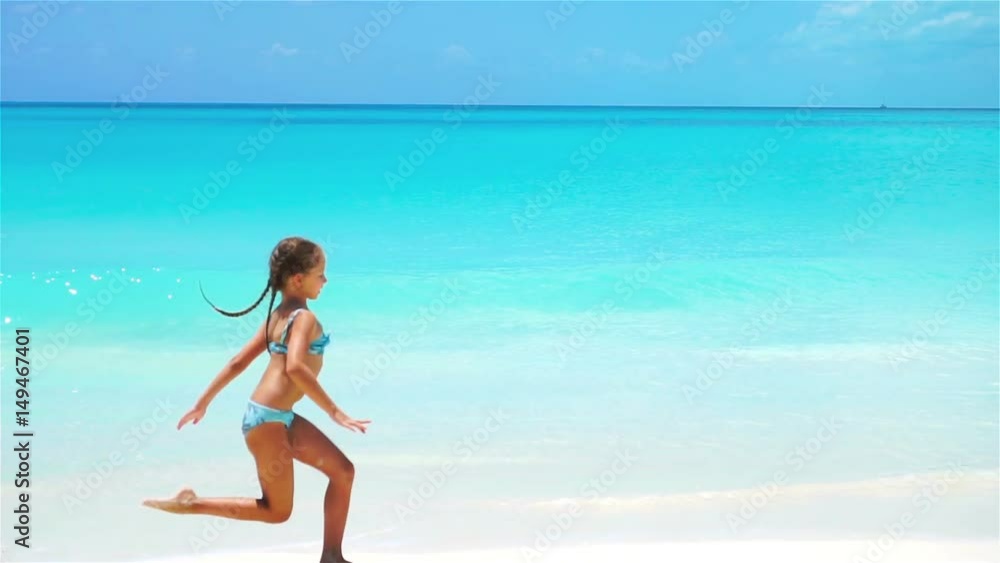 Adorable little girl at beach having a lot of fun. Sporty active kid in slow motion Adorable little girl at beach having a lot of fun. Sporty active kid in slow motion