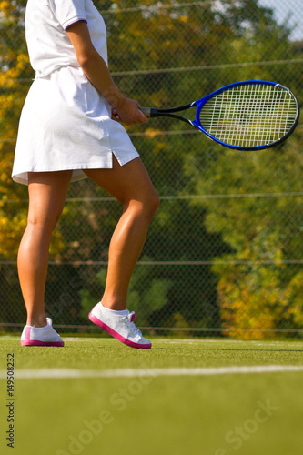 girl stands with racket on court at sunny summer day © fototvv