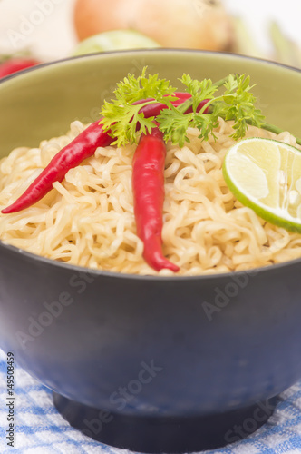 Instant noodles in bowl on wood background