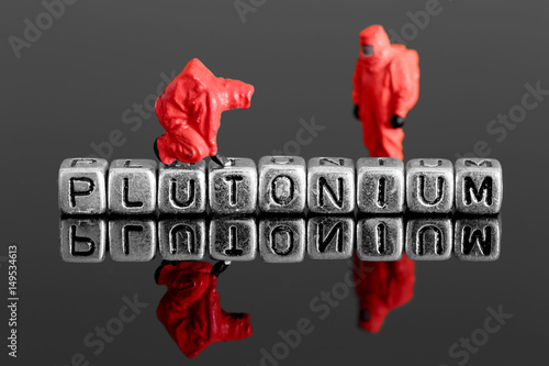 Miniature scale model team in chemical suits with the word plutonium on beads