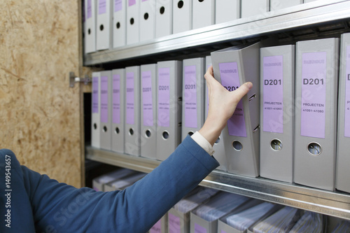 hand reaching for document holder in a cupboard 
