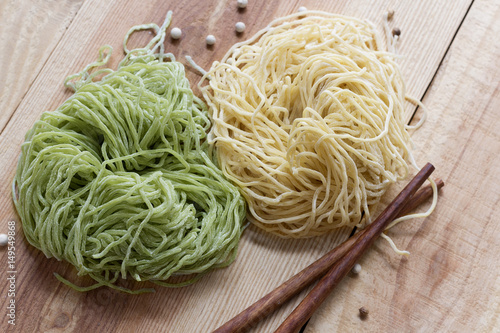 Noodle fresh eggs and chopsticks are on wood table.
