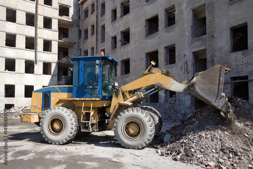 Heavy forklift front loader is working on the reconstruction of an old residential house, Kronstadt Heavy forklift front loader is working on the reconstruction of an old residential house, Kronstadt