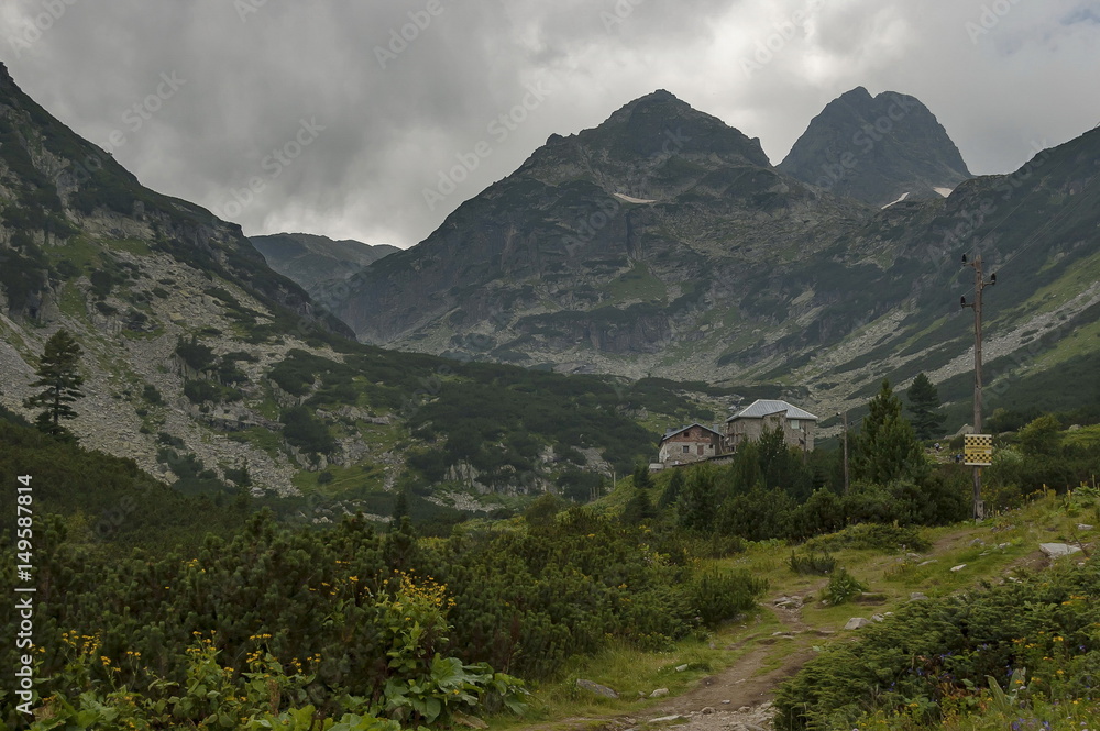Mountain overgrown with coniferous forest, glade and rest-house toward Maliovitza peak in Rila mountain, Bulgaria  