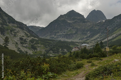 Mountain overgrown with coniferous forest, glade and rest-house toward Maliovitza peak in Rila mountain, Bulgaria 