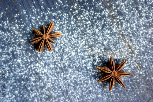 Star anise and flour on dark wooden background